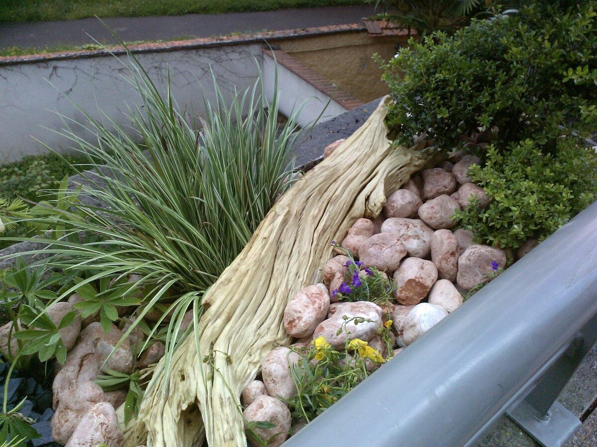 Jardinière de balcon avec bois flotté, galets roses et graminées